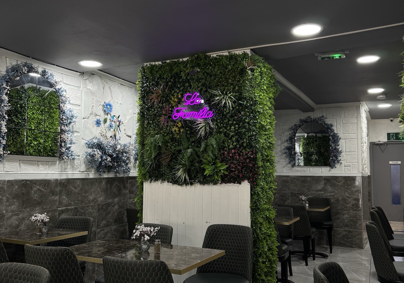 The dining room at La Familia, with its living green wall and neon sign